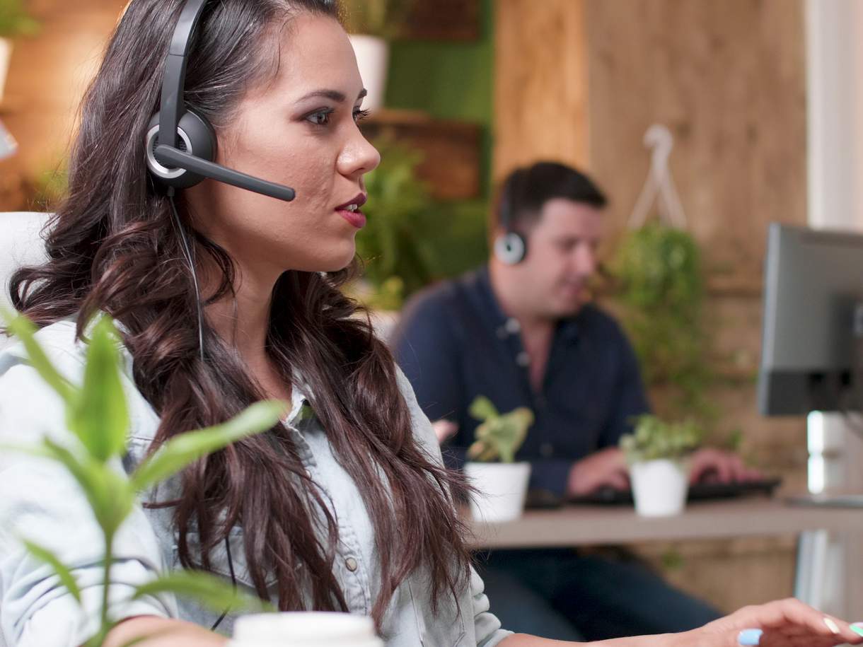 Agentes de atención al cliente con auriculares trabajando en la oficina