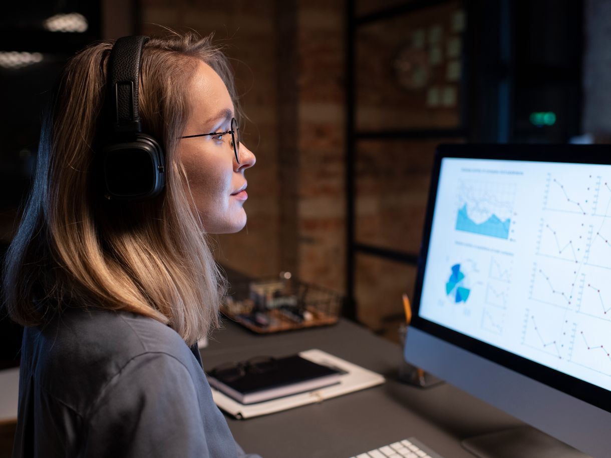 Agente con auriculares analizando datos en el monitor